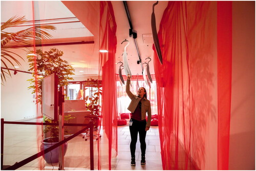 Figure 2. Visitor unhooking a cut-out Leishmania shape from the ceiling in Para-Site-Seeing: Departure Lounge. ©Erika Stevenson 2019.