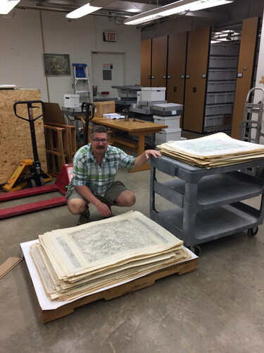 Figure 2. Greg March, UT Map Librarian, loading maps (larger maps on bottom) in the basement of Hoskins Library. (Photo courtesy of Jeff French.)