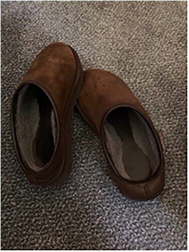 Image 1. Bounded in slippers (R4). Image 1 was taken by the participant in their home at the beginning of the pandemic. The two slippers are sitting next to each other but with the toes pointed inwards. The image is presented and used to inform the researchers that the participant has been wearing her slippers at home during her working day. This is because her working life, since the pandemic started, has been constrained to using her computer in her home and she has been unable to meet any students face-to-face. The slippers are old and well-used and rather forlorn, denoting how often she has worn them and how isolated she has been from other people because she is unable to leave her home.