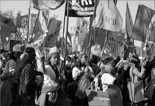 Fig. 6. Waving flags of the Asian Migrant Coordinating Body (AMCB), the Thai Regional Alliance, the International League of People's Struggle (ILPS), the Asia Pacific Mission for Migrants, Migrante International, and others, migrant domestic workers join the anti-WTO march on 11 December 2005.